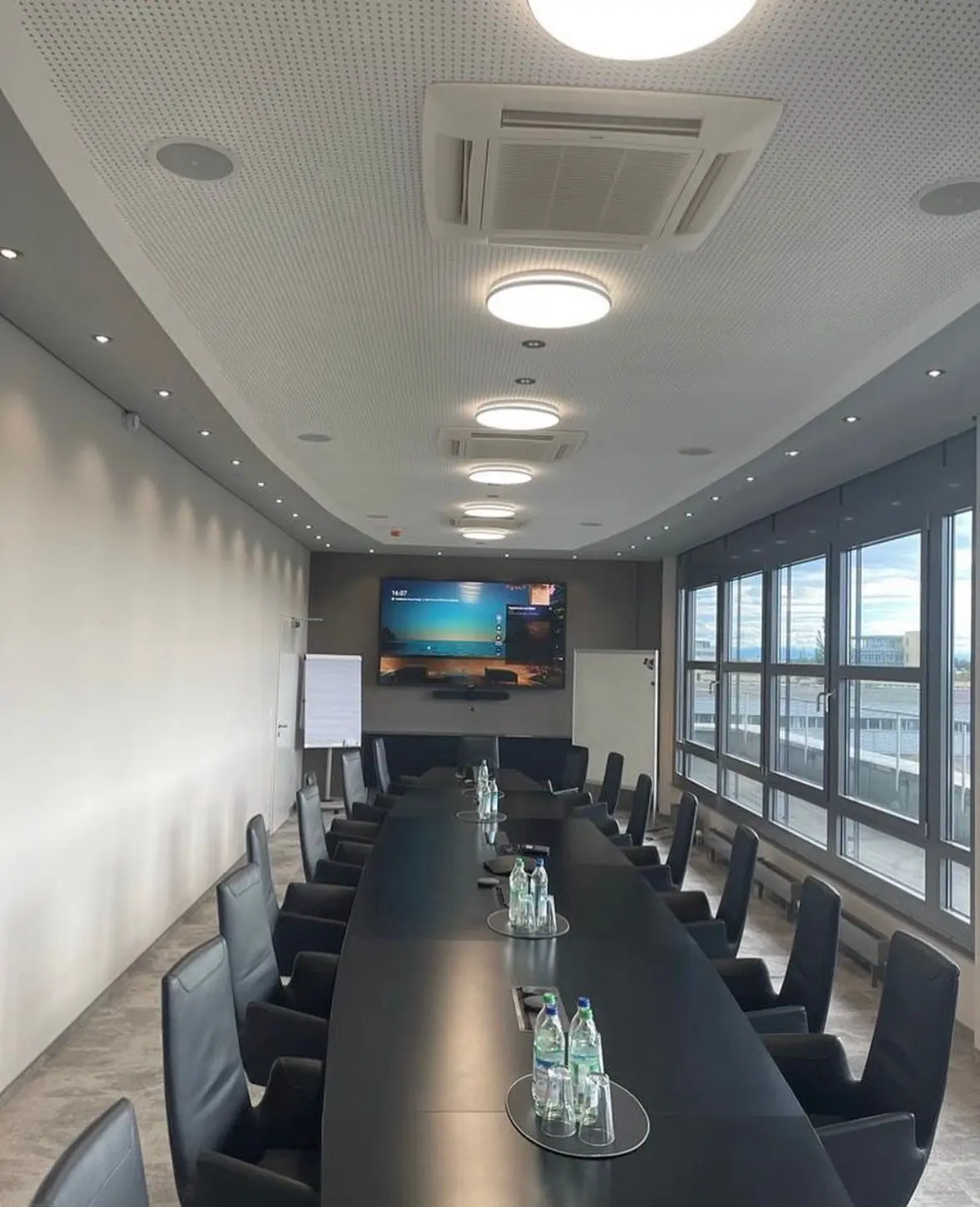 Konferenzraum mit langer Tafel und Medientechnik