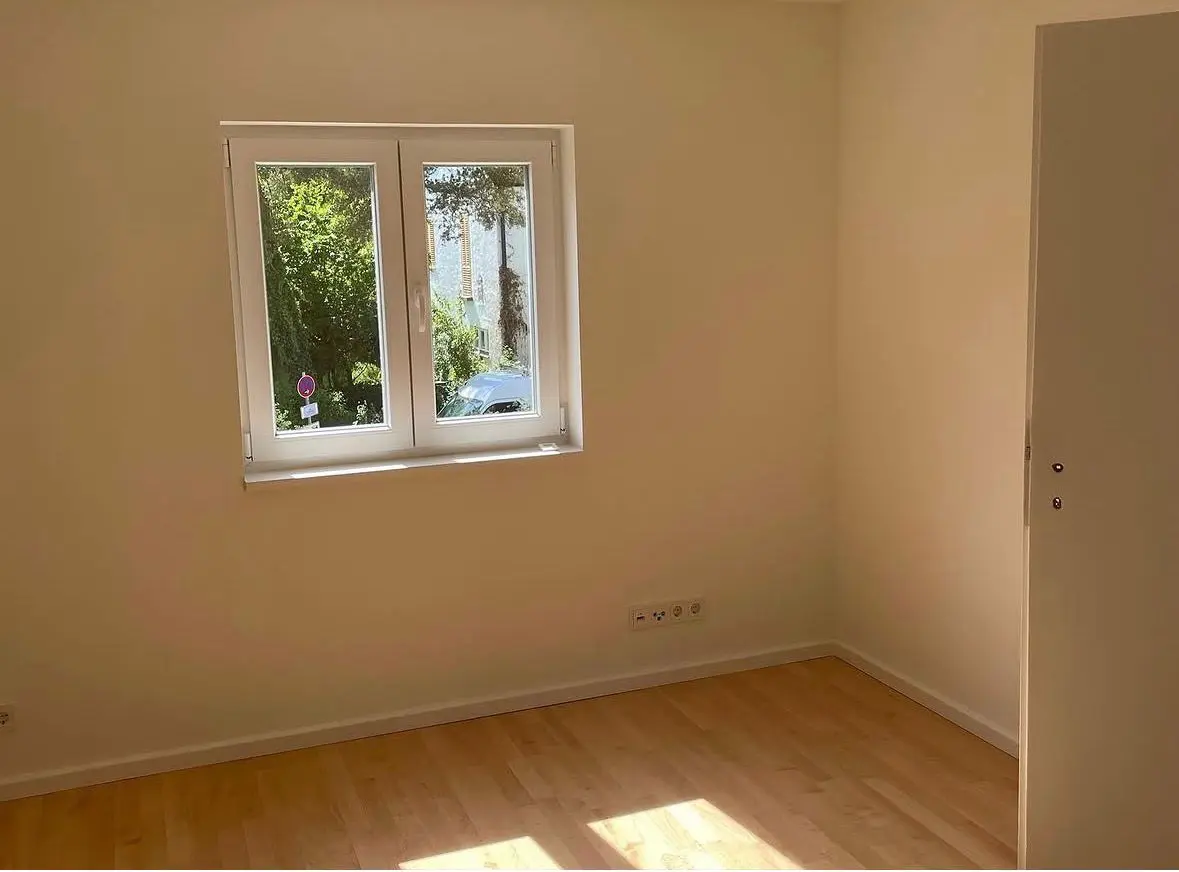 Saniertes Zimmer mit neuem Holzboden und Fenster